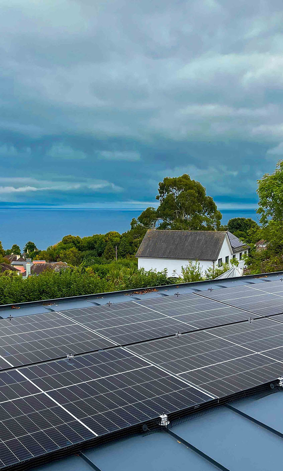 Solar panels on a roof with ocean in the background