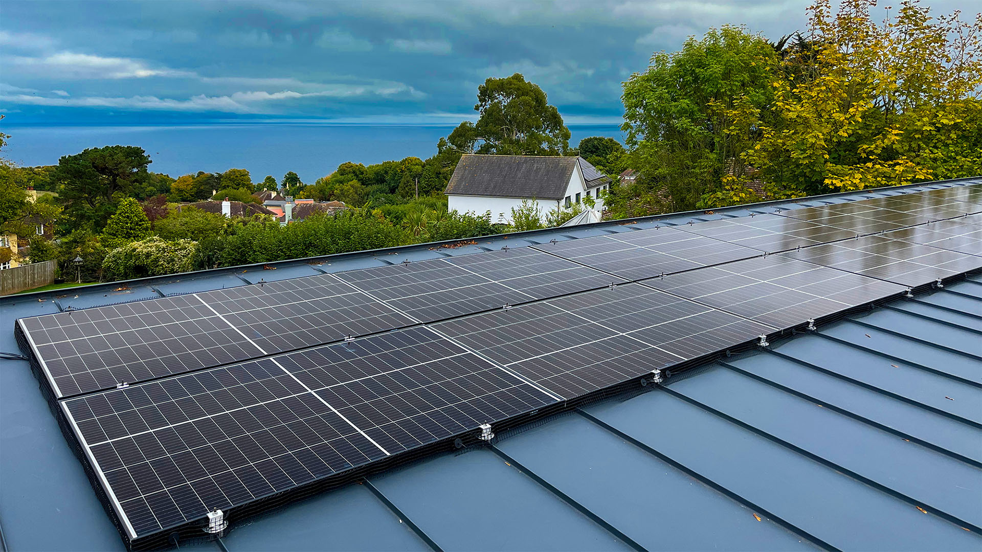 Solar panels on a roof with ocean in the background