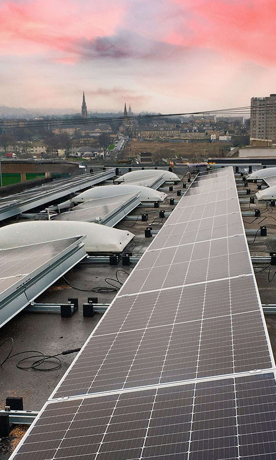 Solar panels on a commercial roof with city background