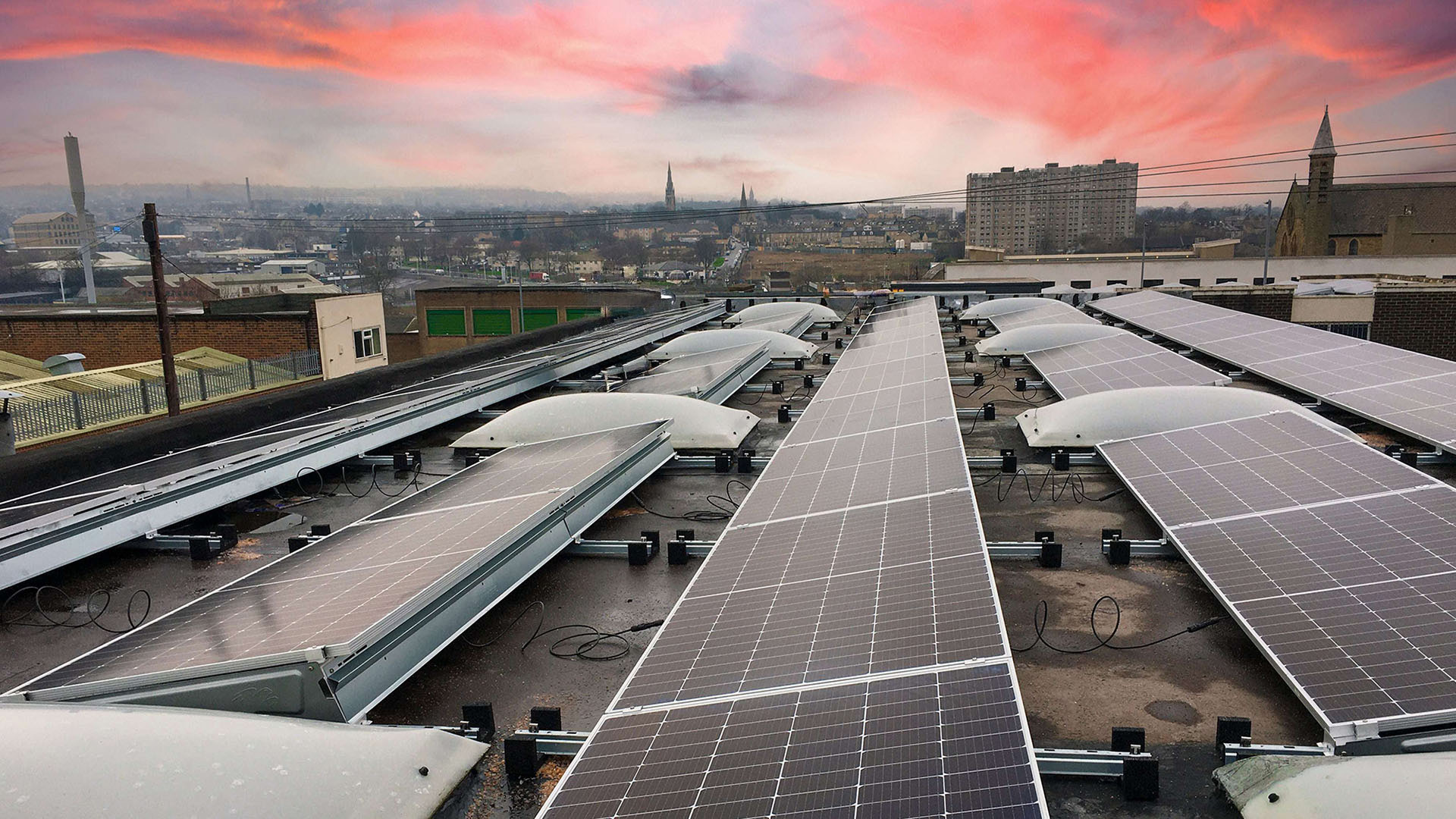 Solar panels on a commercial roof with city background