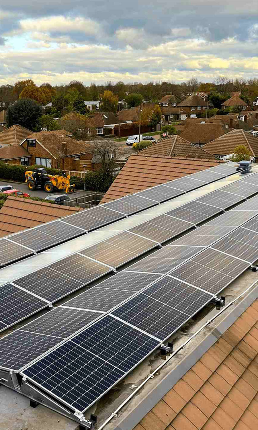 Solar panels on a commercial roof with surrounding neighbourhood in the background