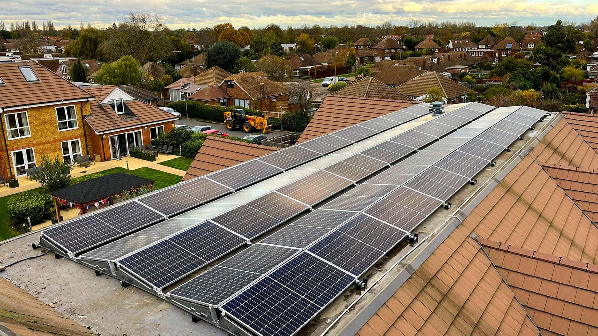 Solar panels on a commercial roof with surrounding neighbourhood in the background