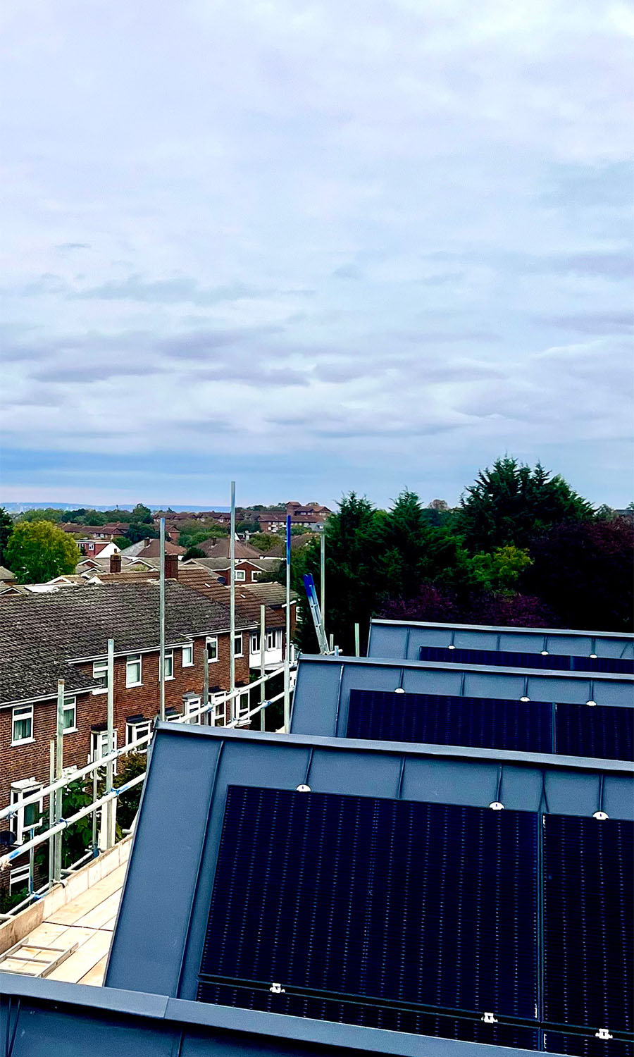 Solar panels on a commercial roof with surrounding town in the background