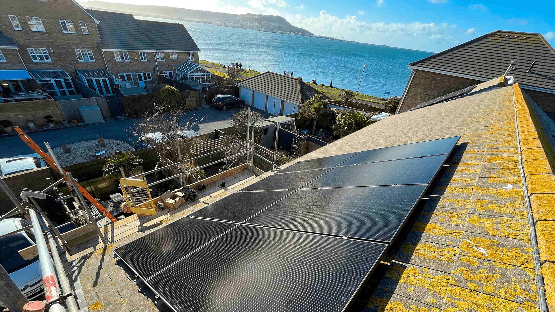 Solar panels on a roof with ocean in the background